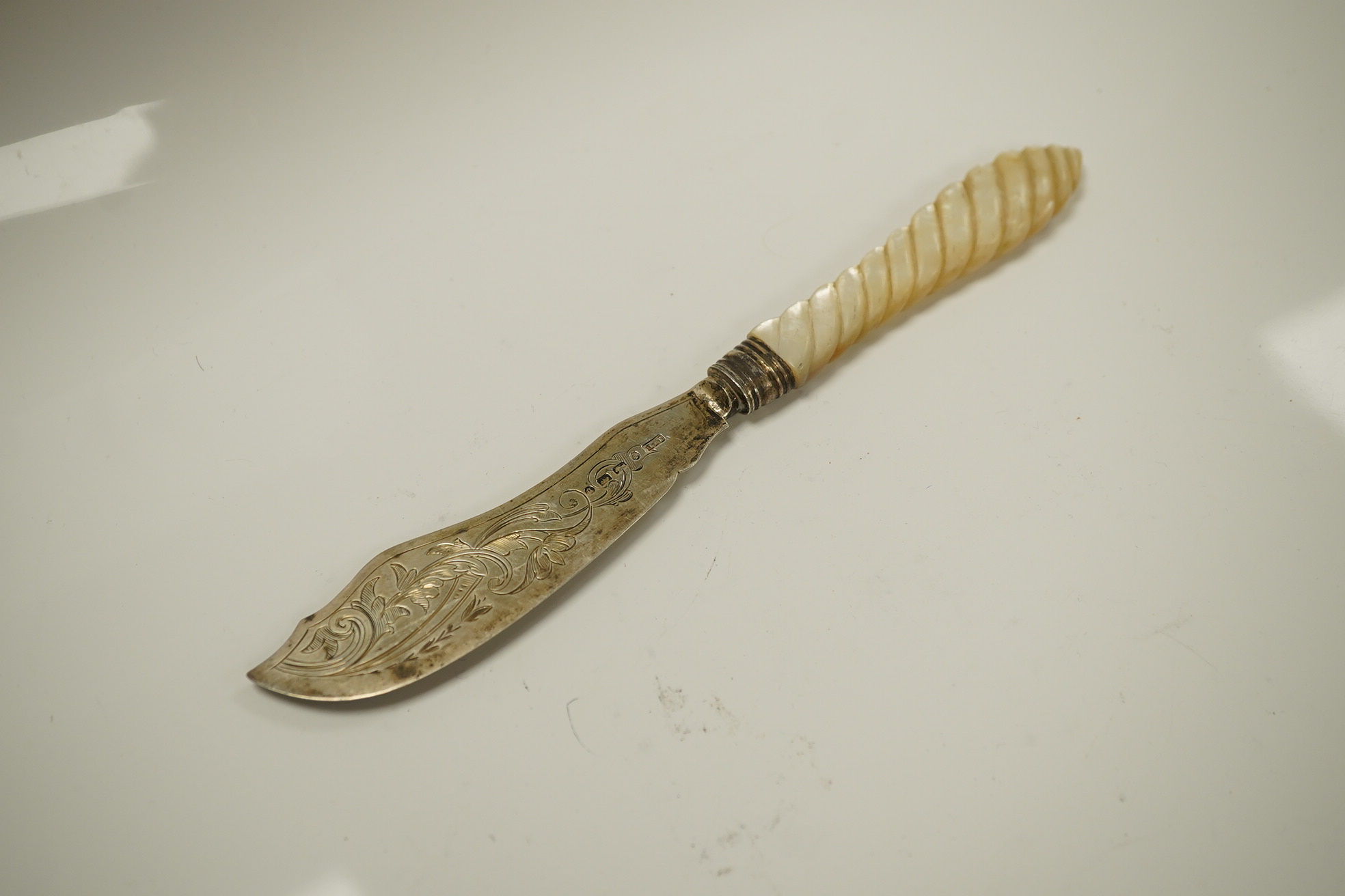 Two Victorian mother of pearl handled butter knives and a Victorian Scottish silver fiddle pattern basting spoon. Condition - fair